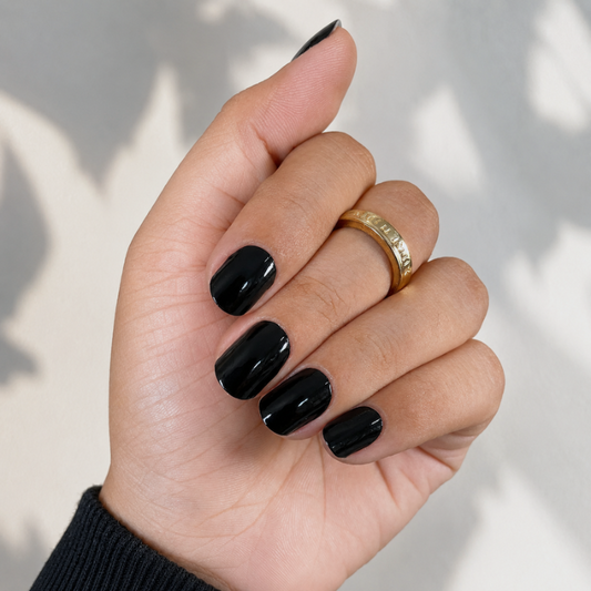 Hand wearing classic black nail wraps by namora
