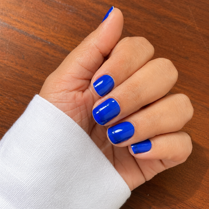 Hand wearing Electric Blue  nail wraps by namora