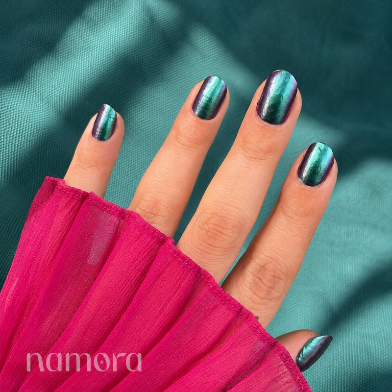 Hands wearing green chrome Nail Wraps by Namora 