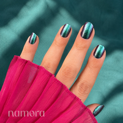 Hands wearing green chrome Nail Wraps by Namora 