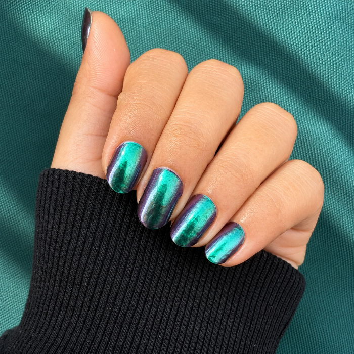 Hands wearing green chrome Nail Wraps by Namora 