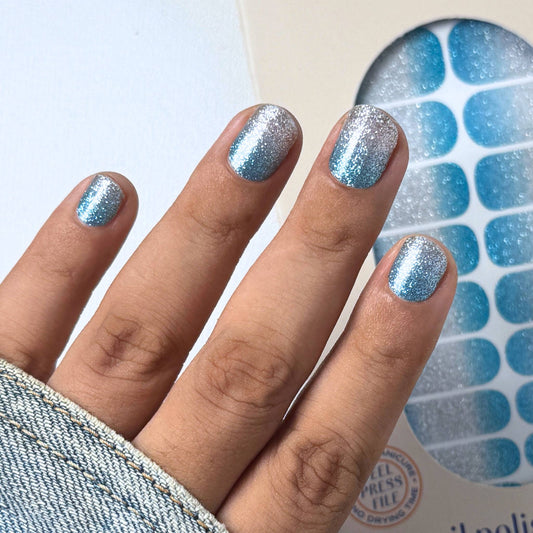 Hand with blue silver glittery nail wraps 