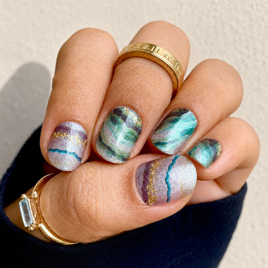 Hand wearing Jade marble nail wraps by Namora