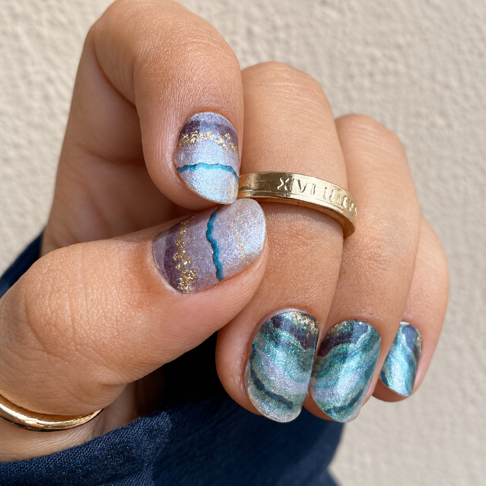 Hand wearing Jade Marble nail wraps by Namora