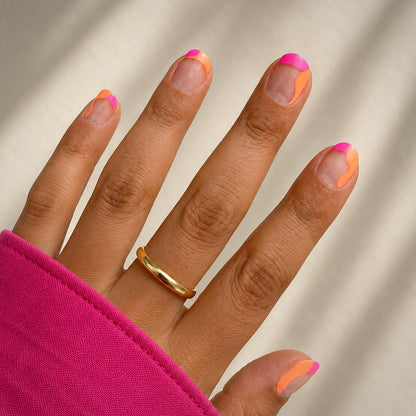 Hand with pink and orange french tips wearing Lola by namora 