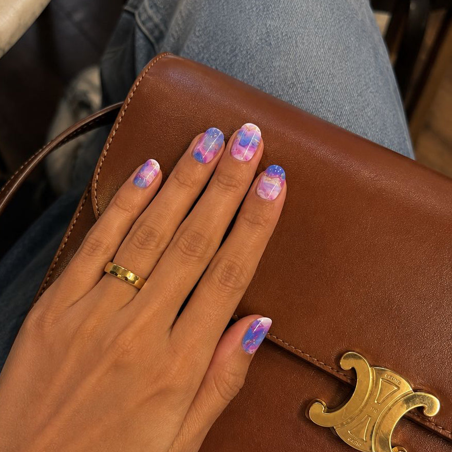 Hand wearing Pink Galaxy nail wraps by namora