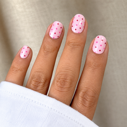 Hand wearing pink & polka nail wraps by namora