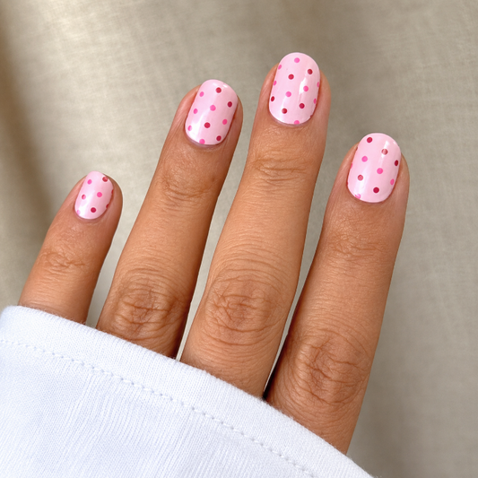 Hand wearing pink & polka nail wraps by namora