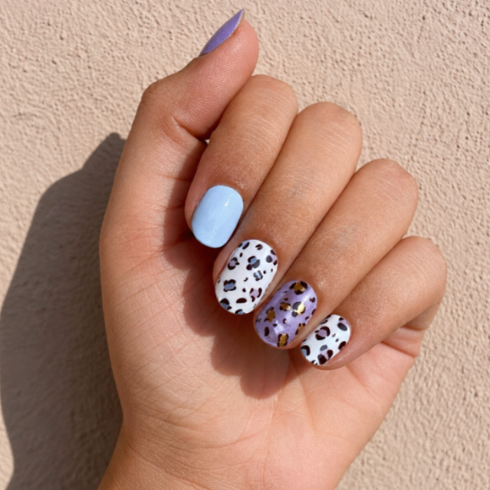 Hand wearing Purple Panther nail wraps by namora