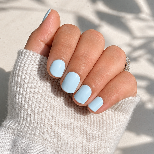 Hand wearing baby blue nail wraps by namora